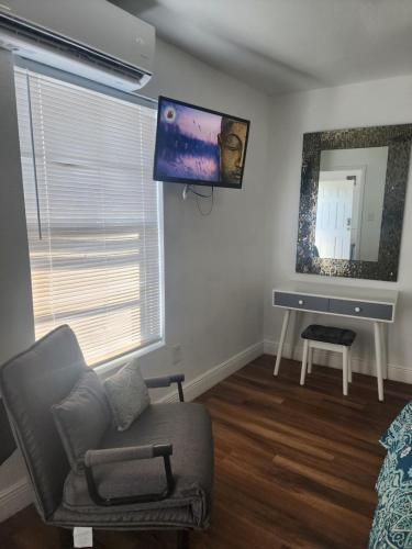 a living room with a chair and a tv on the wall at Diamond 2 in Tampa