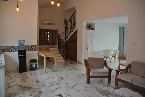 sala de estar con suelo de mármol y escalera en +221 Lagune Beach House, en Mbodiène