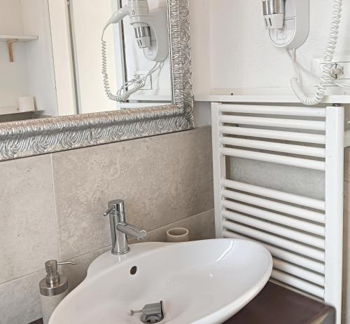 bagno con lavandino bianco e specchio di Kasakiwi Apartment a Vicenza