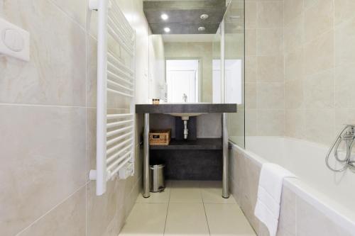 ein Badezimmer mit einer Badewanne, einem Waschbecken und einer Badewanne in der Unterkunft Greg YourHostHelper in Cannes