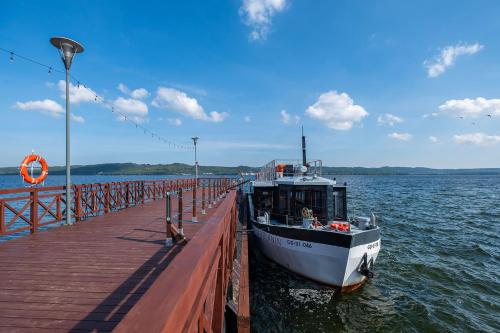 a boat is docked at a dock on the water at 4 Pory Roku Apartamenty Domki Pokoje in Nadole