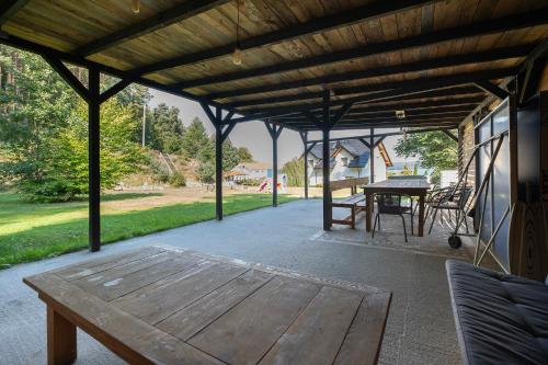 a patio with a wooden bench and a table at 4 Pory Roku Apartamenty Domki Pokoje in Nadole