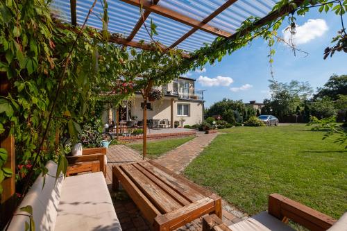 a patio with two wooden benches in a yard at 4 Pory Roku Apartamenty Domki Pokoje in Nadole