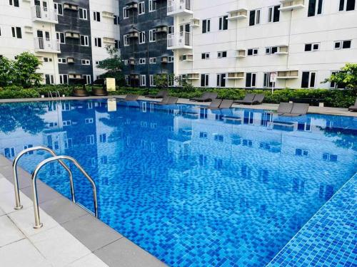 a large swimming pool in front of a building at Newly Furnished 2BR -Condo in Cainta Rizal in Manila