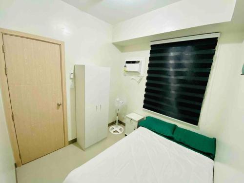 1 dormitorio con cama, ventana y aseo en Newly Furnished 2BR -Condo in Cainta Rizal, en Manila