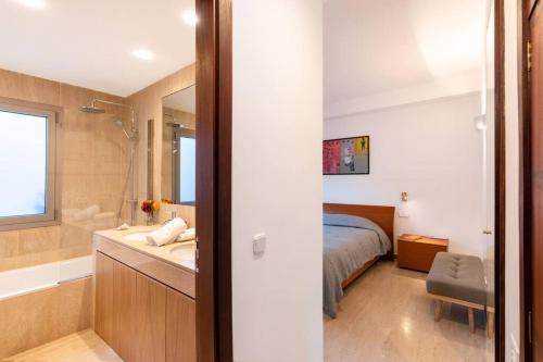 a bedroom with a bed and a bathroom with a sink at Las Rocas Beach-Ciutat Jardi Playa in Palma de Mallorca