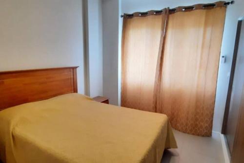 - une chambre avec un lit jaune et une tête de lit en bois dans l'établissement Cozy 2 bedroom, à Quatre Bornes