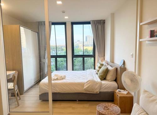 a bedroom with a bed and a large window at Cozy Room in Bangkok, BTS Onnut (E9) Station in Bangkok