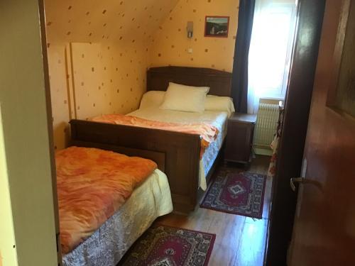 twee bedden in een kleine kamer met een raam bij Maison individuelle dans les Vosges du nord in Niederbronn-les-Bains