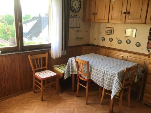une cuisine avec une table et des chaises et une fenêtre dans l'établissement Maison individuelle dans les Vosges du nord, à Niederbronn-les-Bains