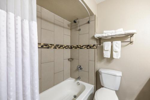 Days Inn by Wyndham Roswell في روزويل: حمام مع حوض استحمام ومرحاض ودش