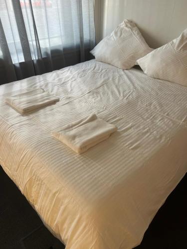 a white bed with two towels on top of it at SleepWell100 in Cologne