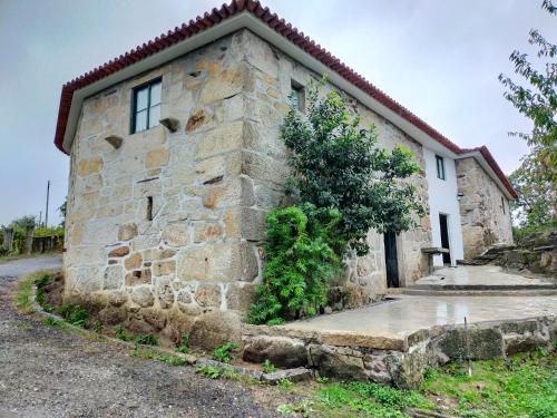 a stone house with a stone wall at Quinta da Lage Agroturismo e Enoturismo in Celorico de Basto