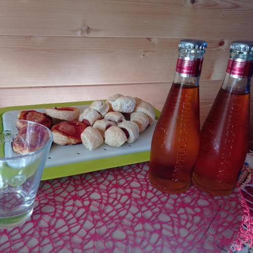a tray of donuts and two bottles of soda at La casetta sotto l'albero LA CAROVANA GITANA in Vasto
