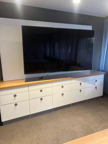 a large entertainment center with a flat screen tv on it at SleepWell100 in Cologne