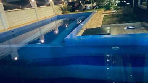 a blue swimming pool with lights in the water at Bright cozy APT in the heart of Naguru in Kampala