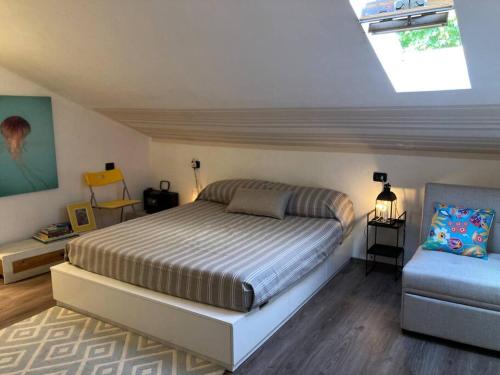 a bedroom with a bed and a chair in it at Casa in pietra al lago di Como in Colico