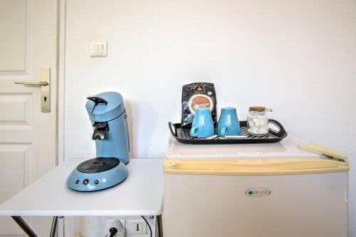 un mixeur bleu assis au-dessus d'un réfrigérateur dans l'établissement Grande chambre au coeur de Montpellier, à Montpellier