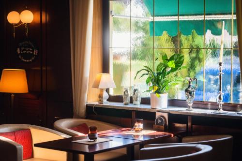 a room with two tables and a window at Hotel am Schlosspark Zum Kurfürst in Oberschleißheim