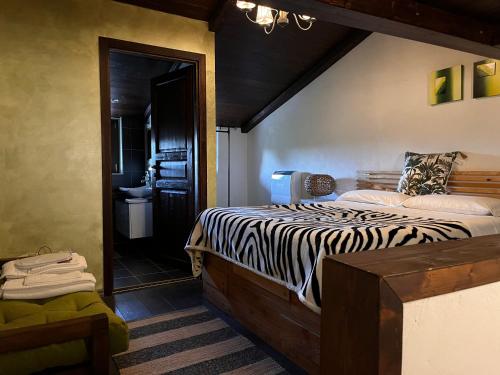 a bedroom with a zebra print bed and a bathroom at CASA MUPI in SantʼEufemia a Maiella