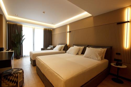une chambre d'hôtel avec deux lits et un canapé dans l'établissement Caramel Boutique Hotel, à Gjirokastër