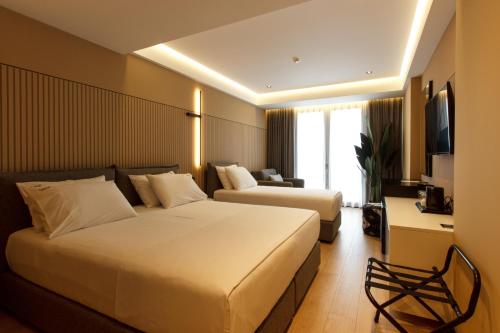 Cette chambre comprend deux lits et une télévision. dans l'établissement Caramel Boutique Hotel, à Gjirokastër