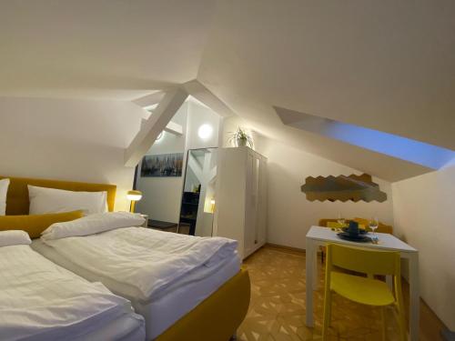 a bedroom with two beds and a table and a desk at Small but Charming-Yellow Appartement in Baden