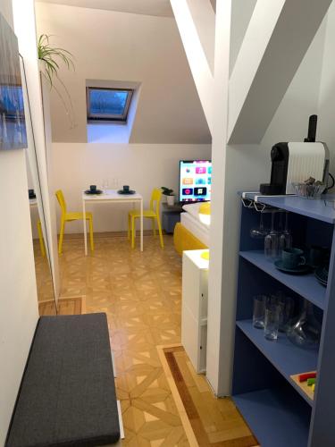 una pequeña sala de estar con mesa y sillas amarillas en Small but Charming-Yellow Appartement, en Baden