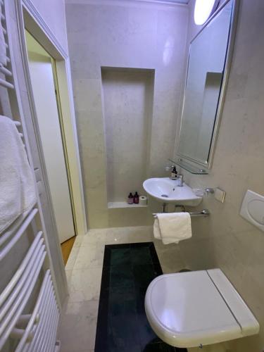 a bathroom with a white toilet and a sink at Small but Charming-Yellow Appartement in Baden