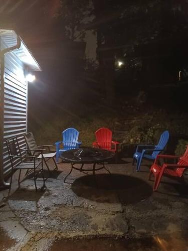 a group of chairs and a table in a fire pit at night at Indian Lake House in Worcester
