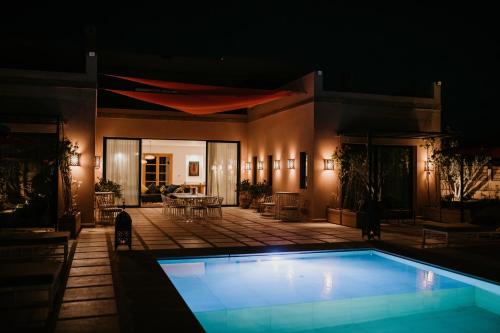- une piscine en face d'une maison la nuit dans l'établissement Villa Aljana Marrakech, à Marrakech