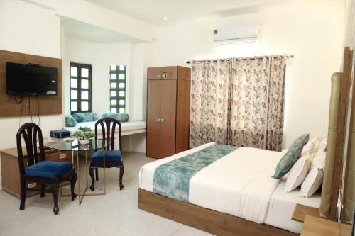 1 dormitorio con cama, mesa y comedor en Hotel Tree of heaven, en Udaipur