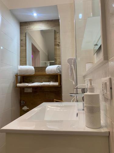 a bathroom with a sink and a mirror and towels at Sweet Room Affittacamere in San Severo