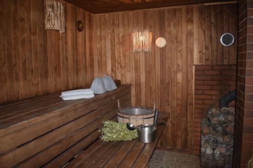 a wooden cabin with a tub and a bucket in it at Pirts "Spārītes" in Geraņimova