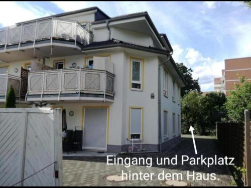a white house with a balcony and a fence at Top Apartment in Langenhagen in Hannover