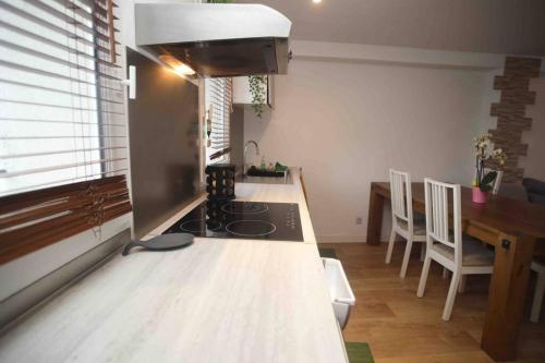 a kitchen with a stove and a table with chairs at Duplex cosy in Marseille