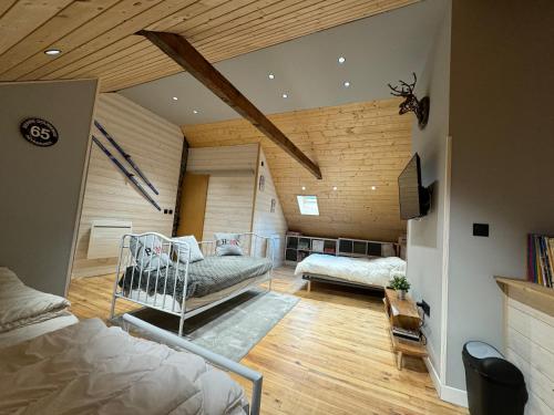 a bedroom with two beds in a room with wooden ceilings at Agréable maison de village au cœur de Sarrancolin in Sarrancolin