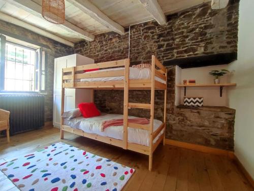 a bedroom with two bunk beds in a brick wall at La Escondida VuT-LE-952 in Caboalles de Abajo