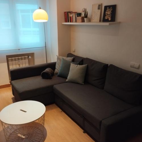 a living room with a black couch and a table at Leon Riverside Flat in León
