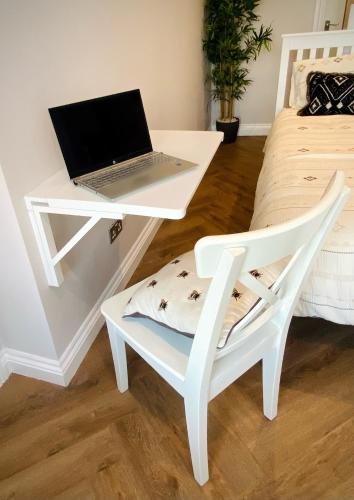 a white desk with a laptop and a chair at Durham City Retreat in Durham