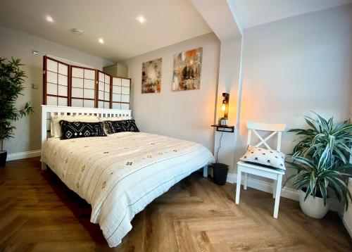 a bedroom with a bed and two plants in it at Durham City Retreat in Durham