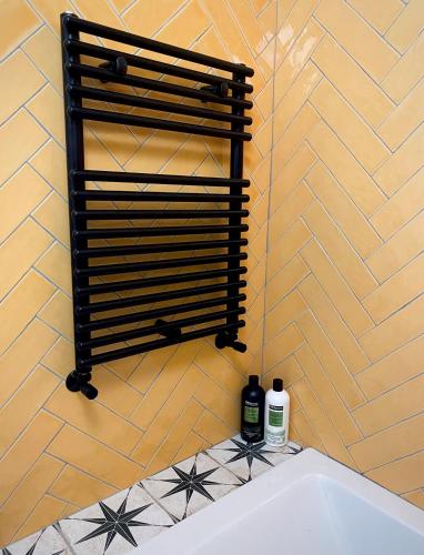 a bath tub with two bottles of wine on a wall at Durham City Retreat in Durham