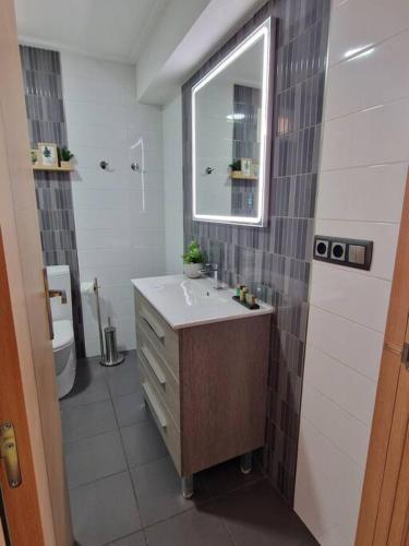 a bathroom with a sink and a mirror and a toilet at Tranquilidad a la Orilla del Mar in Villajoyosa