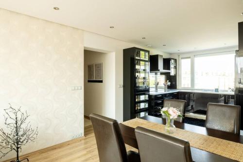 a kitchen and dining room with a table and chairs at Martonfalvi Penthouse w Jacuzzi in Debrecen