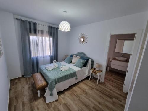 Villa La Escollera Ronda في أرياتي: غرفة نوم بسرير وبطانية خضراء