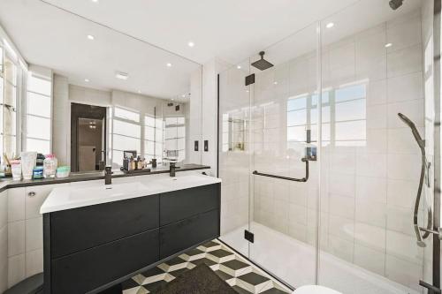 a bathroom with a shower and a sink and a tub at Luxury Kensington Flat with Terrace and AC in London