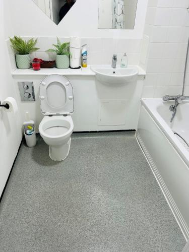 a white bathroom with a toilet and a sink at One Bedroom Apartment Barking in Barking