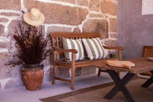 a bench with two pillows on it next to a table at Quinta de São Francisco Houses in Viseu
