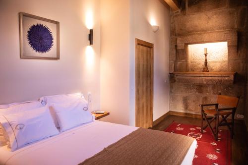 a bedroom with a bed and a chair in a room at Quinta de São Francisco Houses in Viseu
