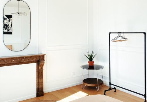 ein Wohnzimmer mit einem Spiegel und einem Tisch in der Unterkunft Le Haussmann ⸱ Stationnement gratuit ⸱ Fibre in Déols